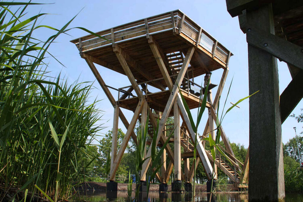 Houten uitkijkplatform op palen in het riet aan het water